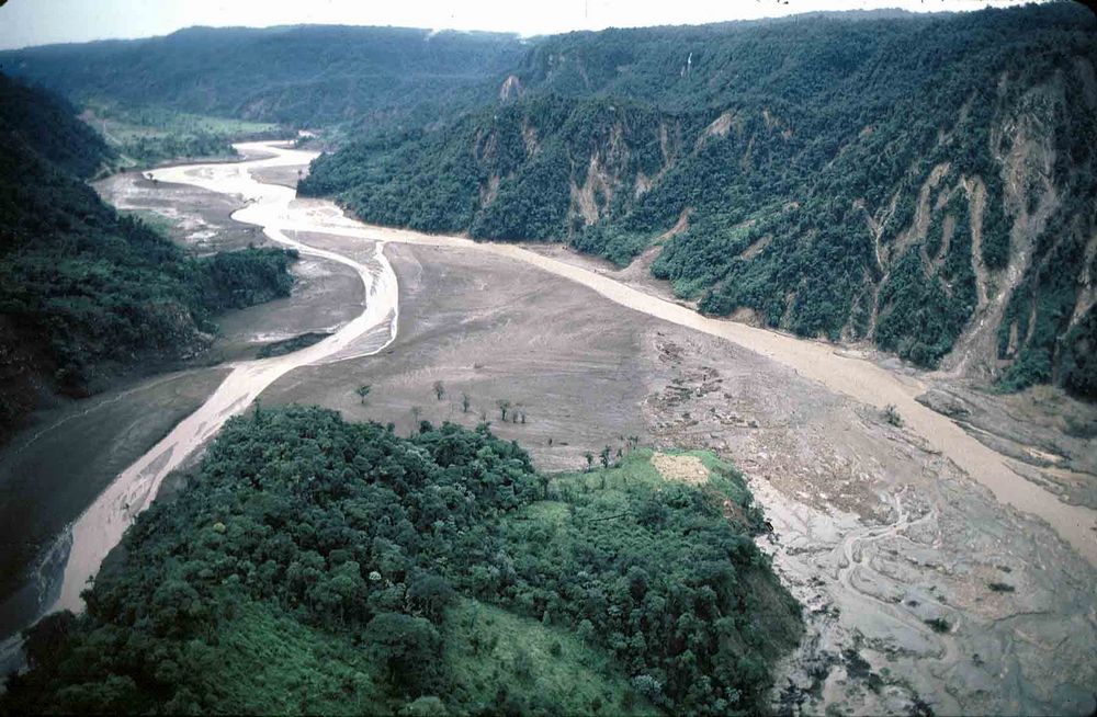 Рис. 12. Вид места слияния рек Рио-Мало (слева) и Рио-Кока (справа) на северо-востоке Эквадора после схода селевых потоков в результате землетрясений в марте 1987 года. Оба речных русла забиты отложениями [25,&nbsp;27]