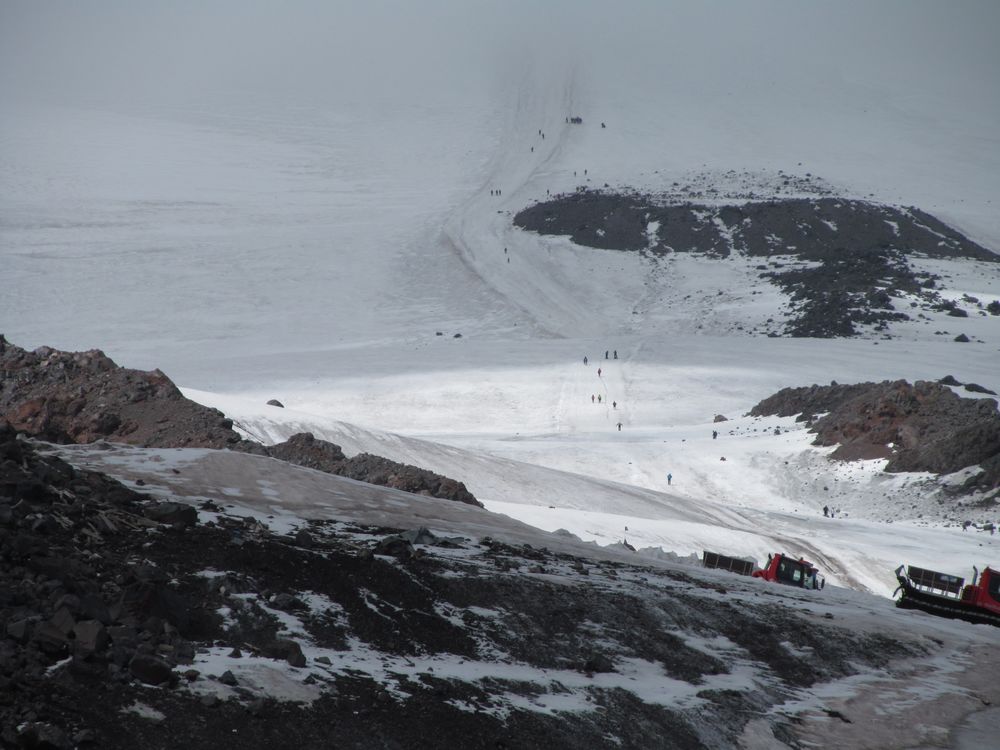 Рис. 7. Обычные туристы, приехавшие на верхнюю станцию канатной дороги, поднимаются на снежный конус Эльбруса по пути, проложенном ратраками, на высоте около 4 км над уровнем моря (фото автора)